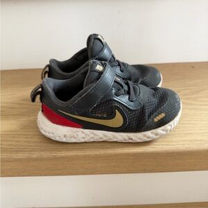 Nike Kids Black Sneakers with Gold Swoosh and Red Heel